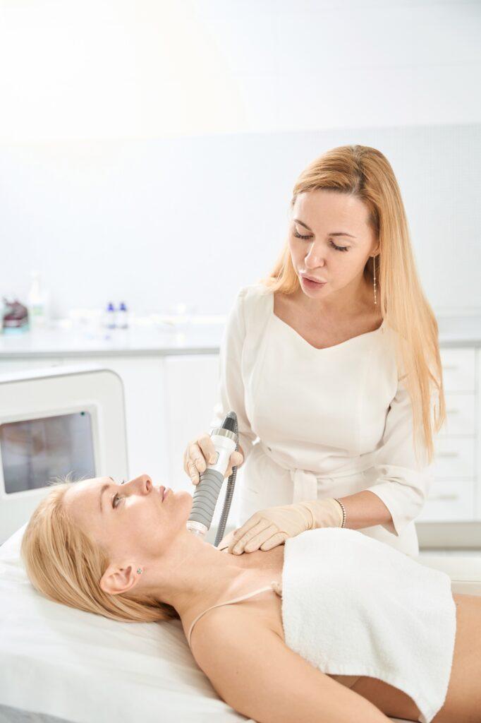 Dermatologist carrying microneedle rf-lifting procedure on the client's neck